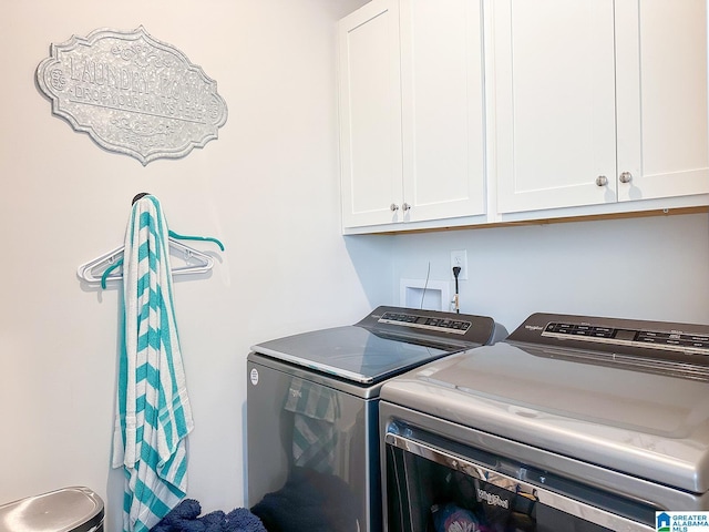 clothes washing area featuring washing machine and dryer and cabinets