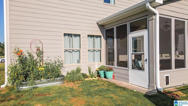 view of side of property featuring a lawn and a sunroom