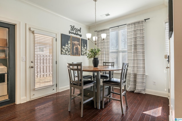 dining room with washer / clothes dryer, crown molding, dark hardwood / wood-style floors, and a chandelier