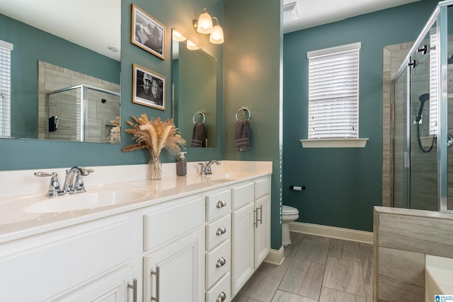 bathroom with vanity, a shower with shower door, and toilet