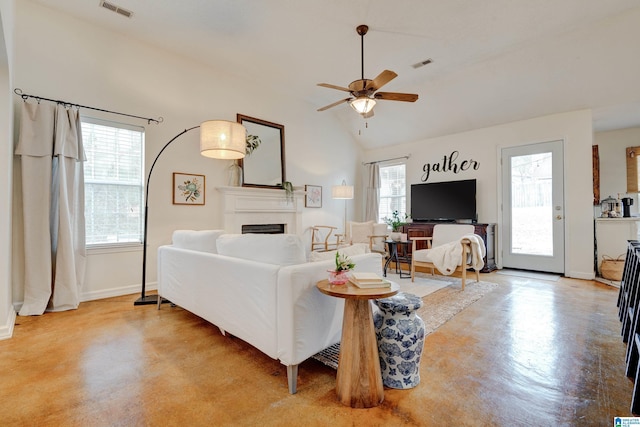 living room featuring lofted ceiling, ceiling fan, and a healthy amount of sunlight