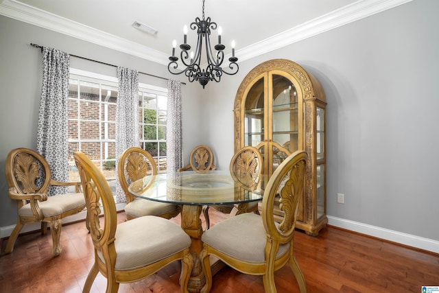 dining area with dark hardwood / wood-style flooring, a notable chandelier, and crown molding