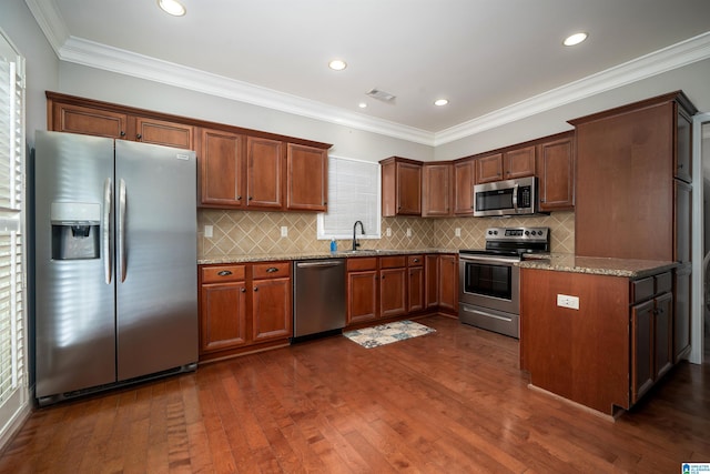 kitchen featuring crown molding, dark wood-type flooring, stainless steel appliances, and stone counters