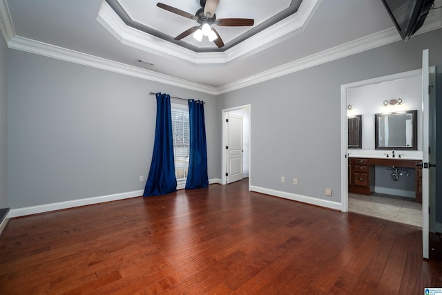 unfurnished bedroom featuring a raised ceiling, crown molding, and hardwood / wood-style floors