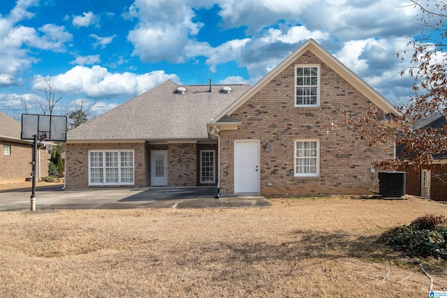 view of front property featuring a front lawn, a patio area, and central air condition unit