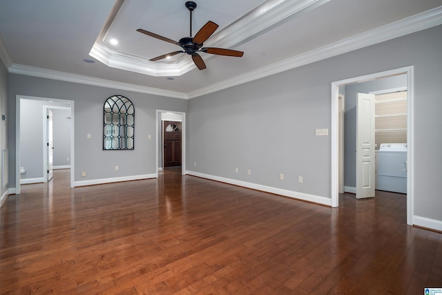 empty room with washer / clothes dryer, ornamental molding, a raised ceiling, and dark hardwood / wood-style floors