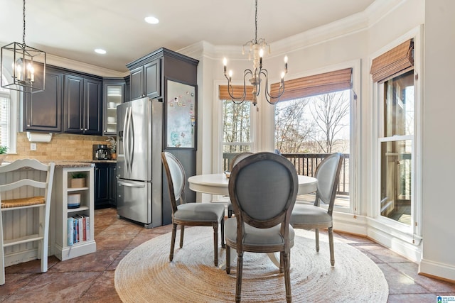 dining room with a notable chandelier and crown molding