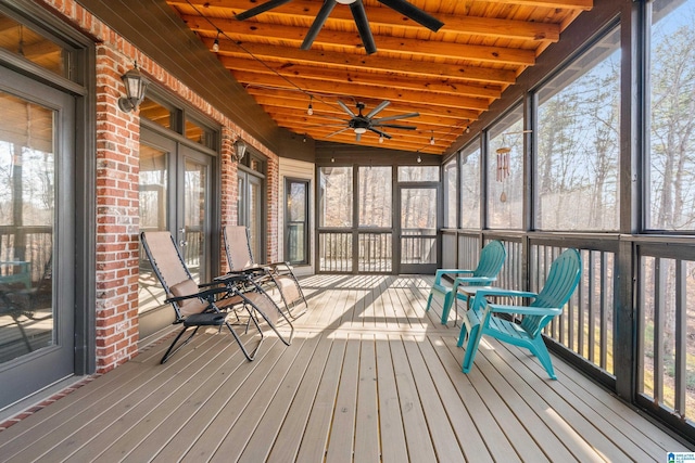 unfurnished sunroom featuring beamed ceiling, ceiling fan, and wood ceiling