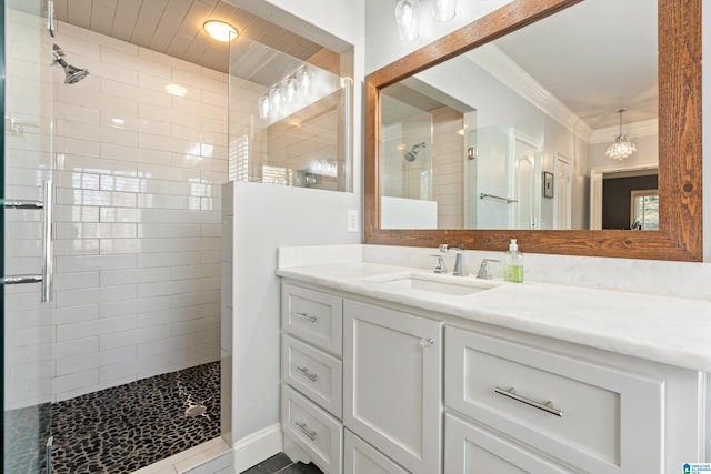 bathroom with crown molding, vanity, and a shower with shower door