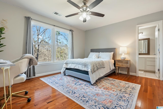 bedroom with wood-type flooring, ceiling fan, and ensuite bathroom