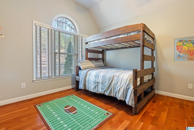 bedroom with wood-type flooring and vaulted ceiling