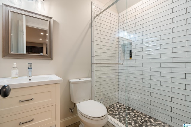 bathroom featuring vanity, a shower with shower door, and toilet