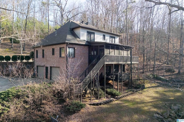 back of property with a garage and a sunroom