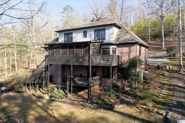 rear view of property with a deck and a sunroom