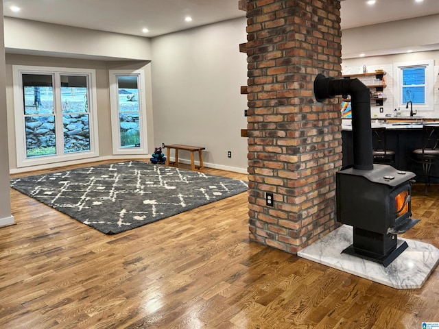 interior space featuring wood-type flooring, sink, and a wood stove