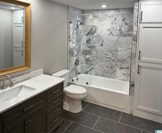 full bathroom with tiled shower / bath, vanity, toilet, and tile patterned flooring