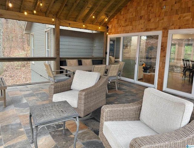 sunroom / solarium featuring lofted ceiling with beams and wooden ceiling