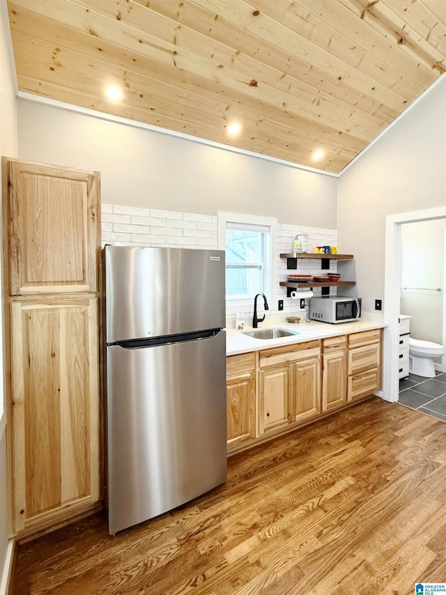 kitchen featuring appliances with stainless steel finishes, lofted ceiling, sink, wood ceiling, and light hardwood / wood-style flooring