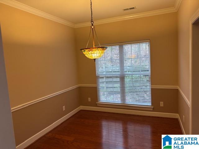 unfurnished room featuring crown molding and dark wood-type flooring