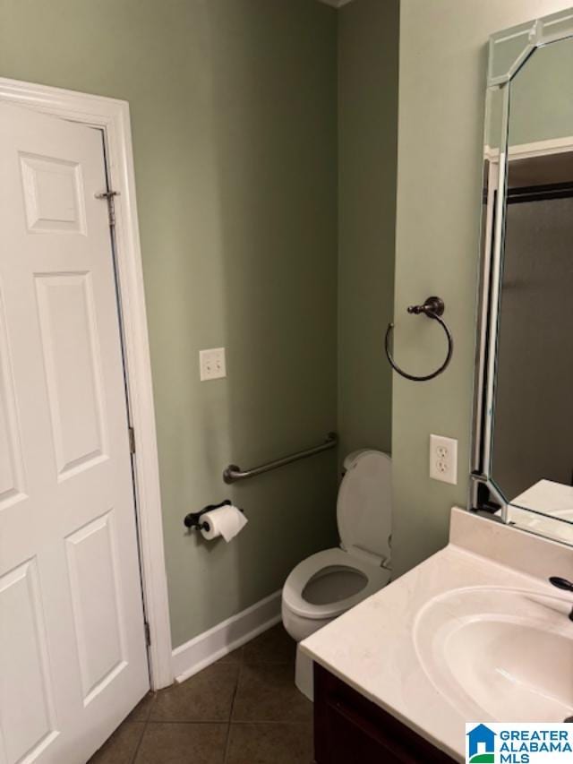 bathroom featuring vanity, tile patterned floors, and toilet