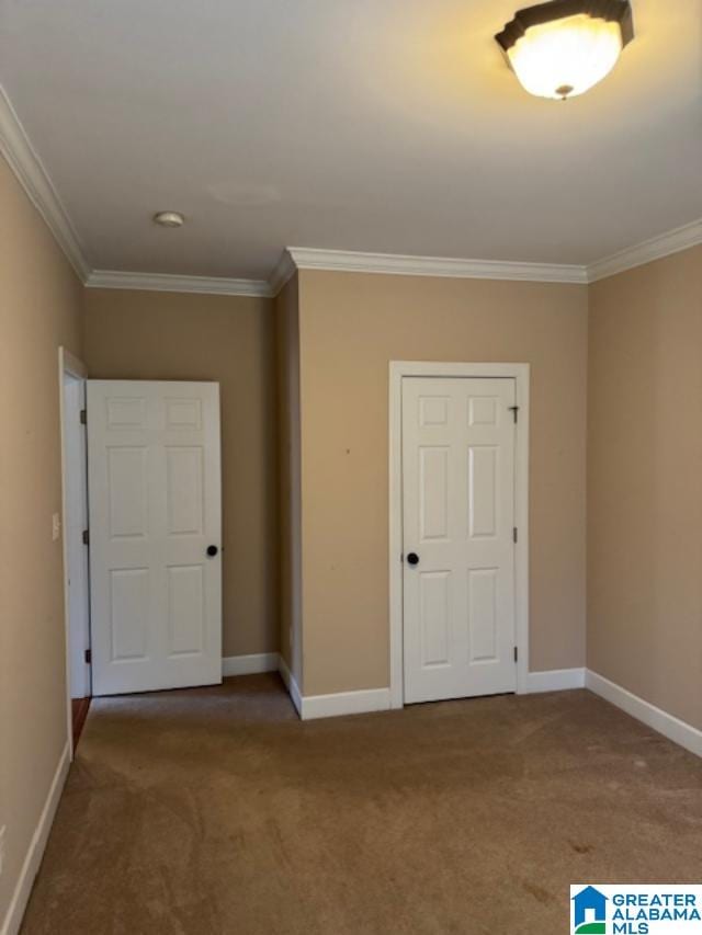 unfurnished bedroom with ornamental molding and carpet flooring