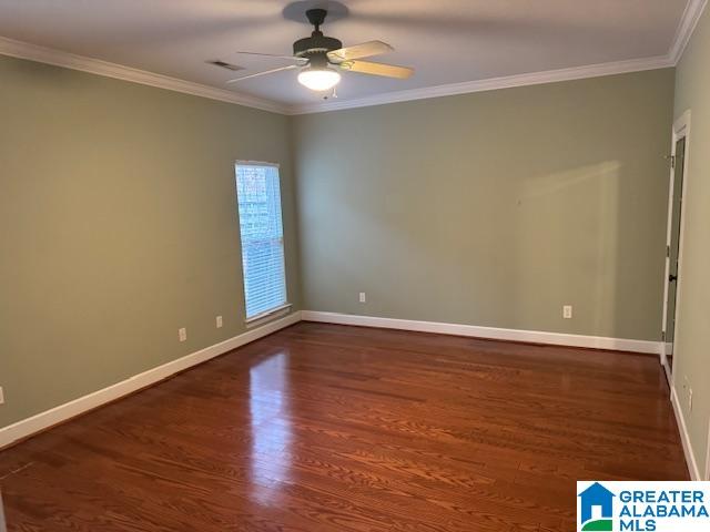 unfurnished room with ornamental molding, dark wood-type flooring, and ceiling fan