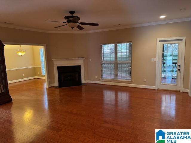 unfurnished living room featuring crown molding, a healthy amount of sunlight, and wood-type flooring
