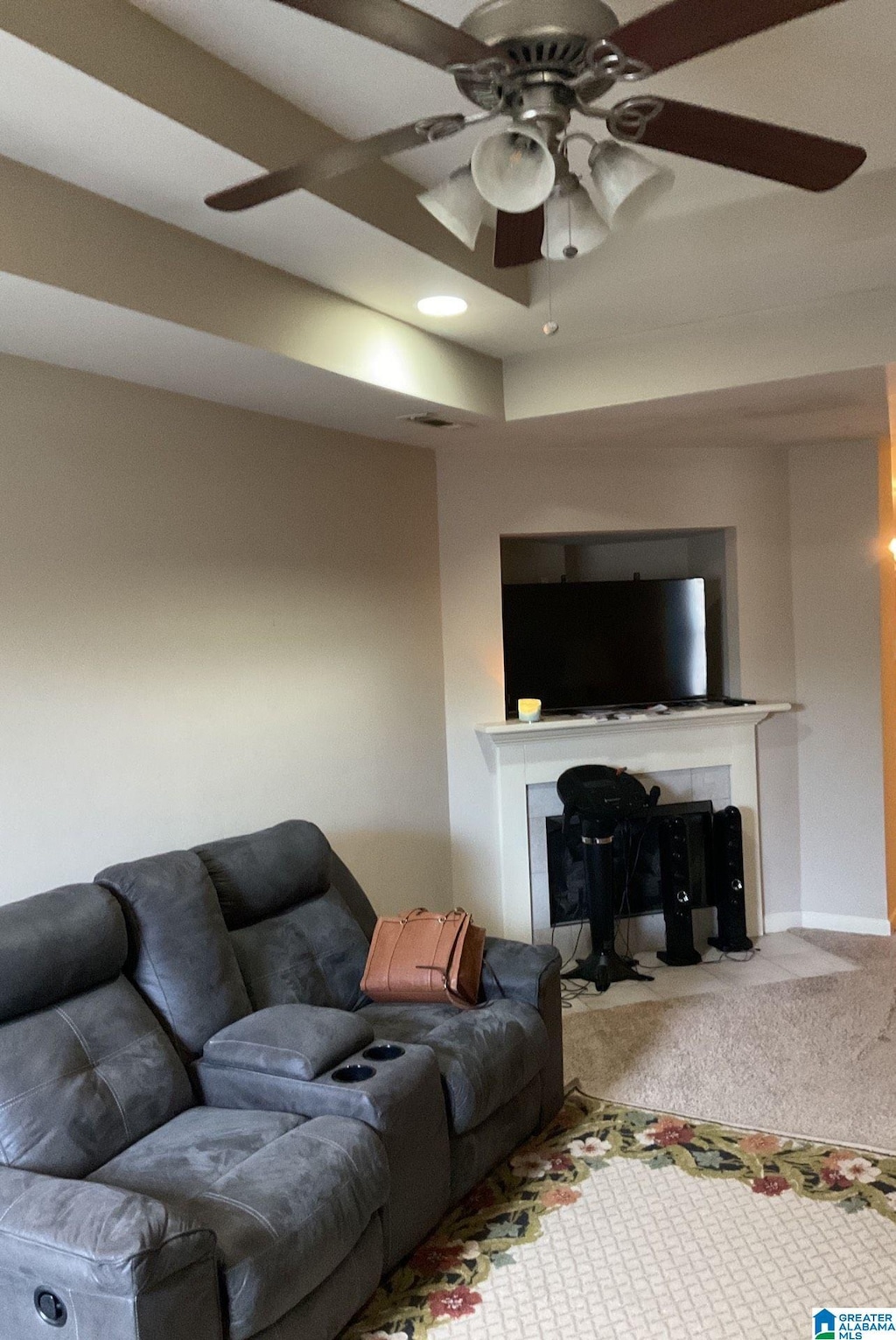 living room with a fireplace with flush hearth, ceiling fan, carpet floors, and baseboards