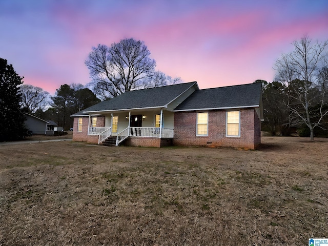 single story home with a porch and a yard