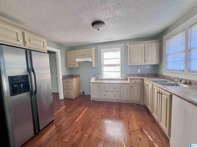 kitchen featuring hardwood / wood-style floors, sink, stainless steel fridge, cream cabinets, and a textured ceiling