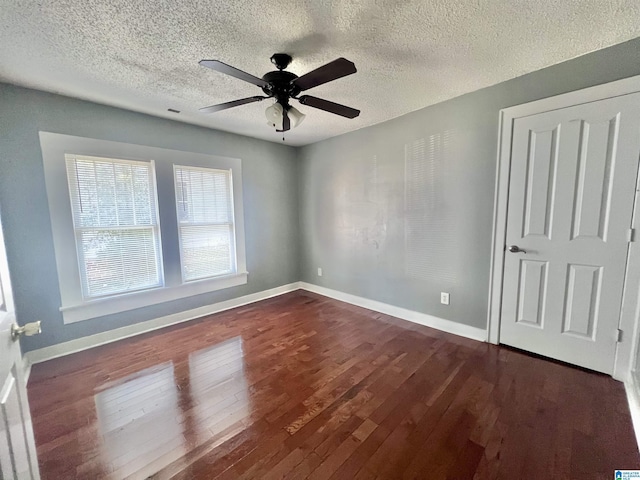 unfurnished room with dark wood-type flooring, ceiling fan, and a textured ceiling