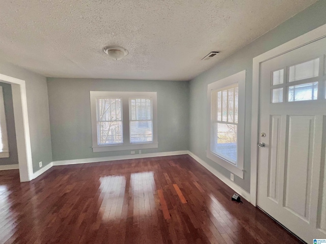 entryway with dark hardwood / wood-style flooring and a textured ceiling