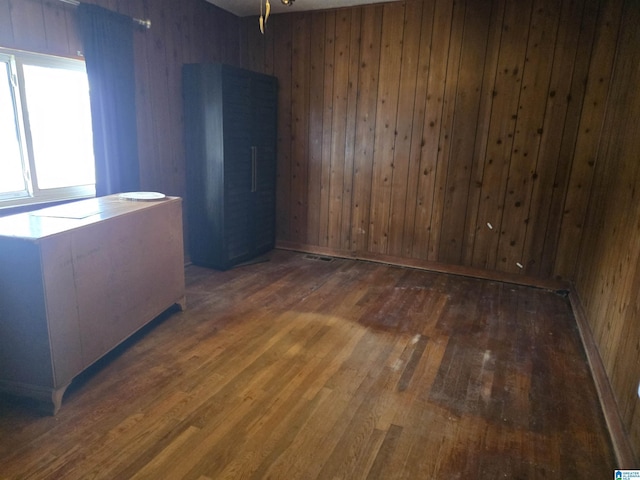 spare room with wooden walls and dark hardwood / wood-style floors