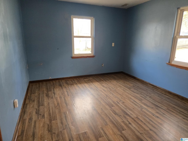 unfurnished room with plenty of natural light and dark hardwood / wood-style floors