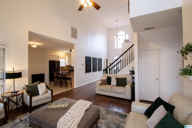 living room featuring dark wood-type flooring, high vaulted ceiling, and ceiling fan