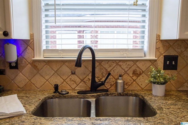 kitchen featuring sink, backsplash, and stone countertops