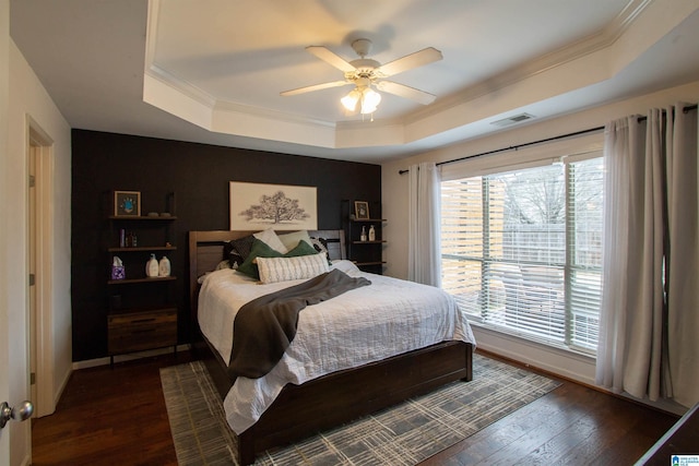 bedroom featuring crown molding, ceiling fan, dark hardwood / wood-style floors, and a raised ceiling