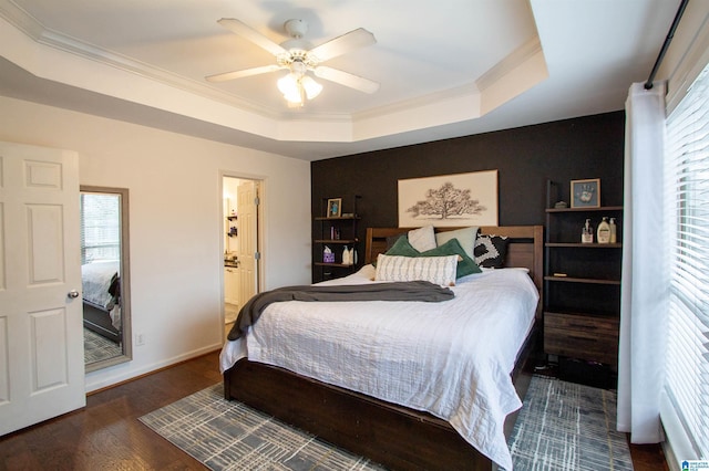 bedroom featuring multiple windows, dark hardwood / wood-style flooring, ornamental molding, and a raised ceiling