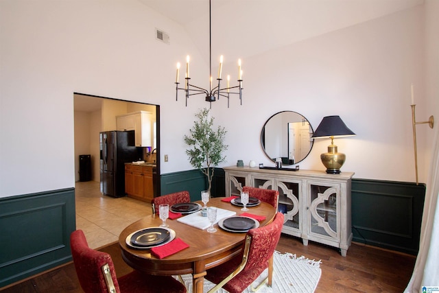 dining area featuring a notable chandelier, vaulted ceiling, and light hardwood / wood-style floors