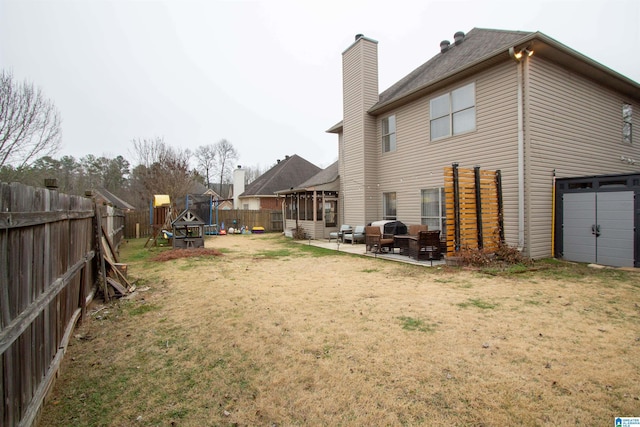 rear view of house with a lawn, a patio, and a playground