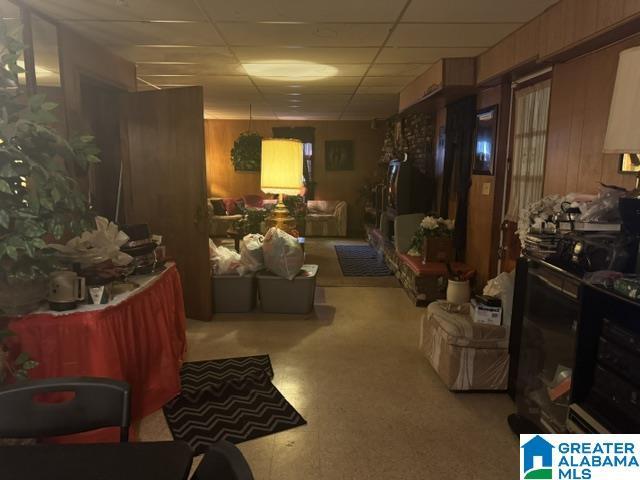 misc room featuring a paneled ceiling and wooden walls