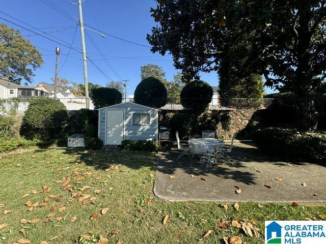 view of yard featuring a storage shed and a patio