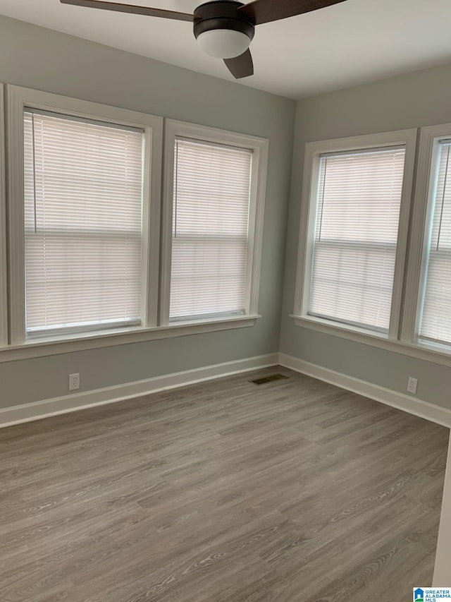 spare room featuring dark wood-type flooring and ceiling fan