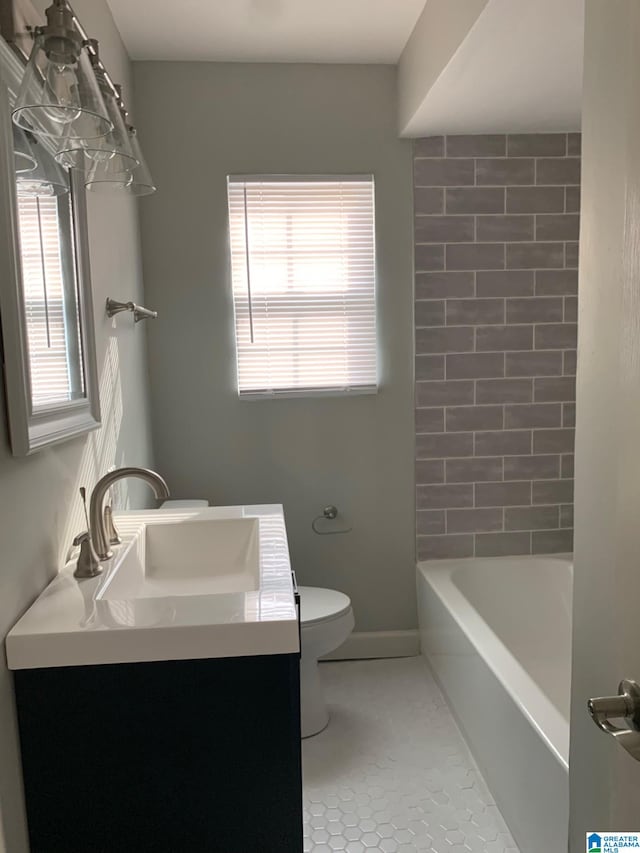 full bathroom featuring tiled shower / bath combo, vanity, tile patterned floors, and toilet