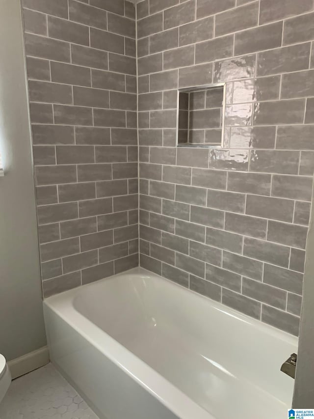 bathroom with tile patterned flooring, shower / tub combination, and toilet