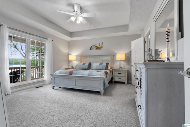 373 Pineywoods Dr, Wedowee, AL 36278 - bedroom with a textured ceiling, light colored carpet, a raised ceiling, and ceiling fan