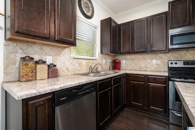 kitchen featuring dark wood-type flooring, sink, crown molding, dark brown cabinets, and appliances with stainless steel finishes