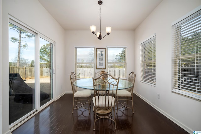 dining room with dark wood-type flooring and a chandelier