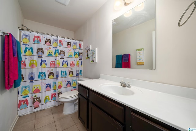 bathroom featuring tile patterned flooring, vanity, toilet, and walk in shower