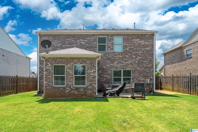 rear view of property with a yard and a patio area